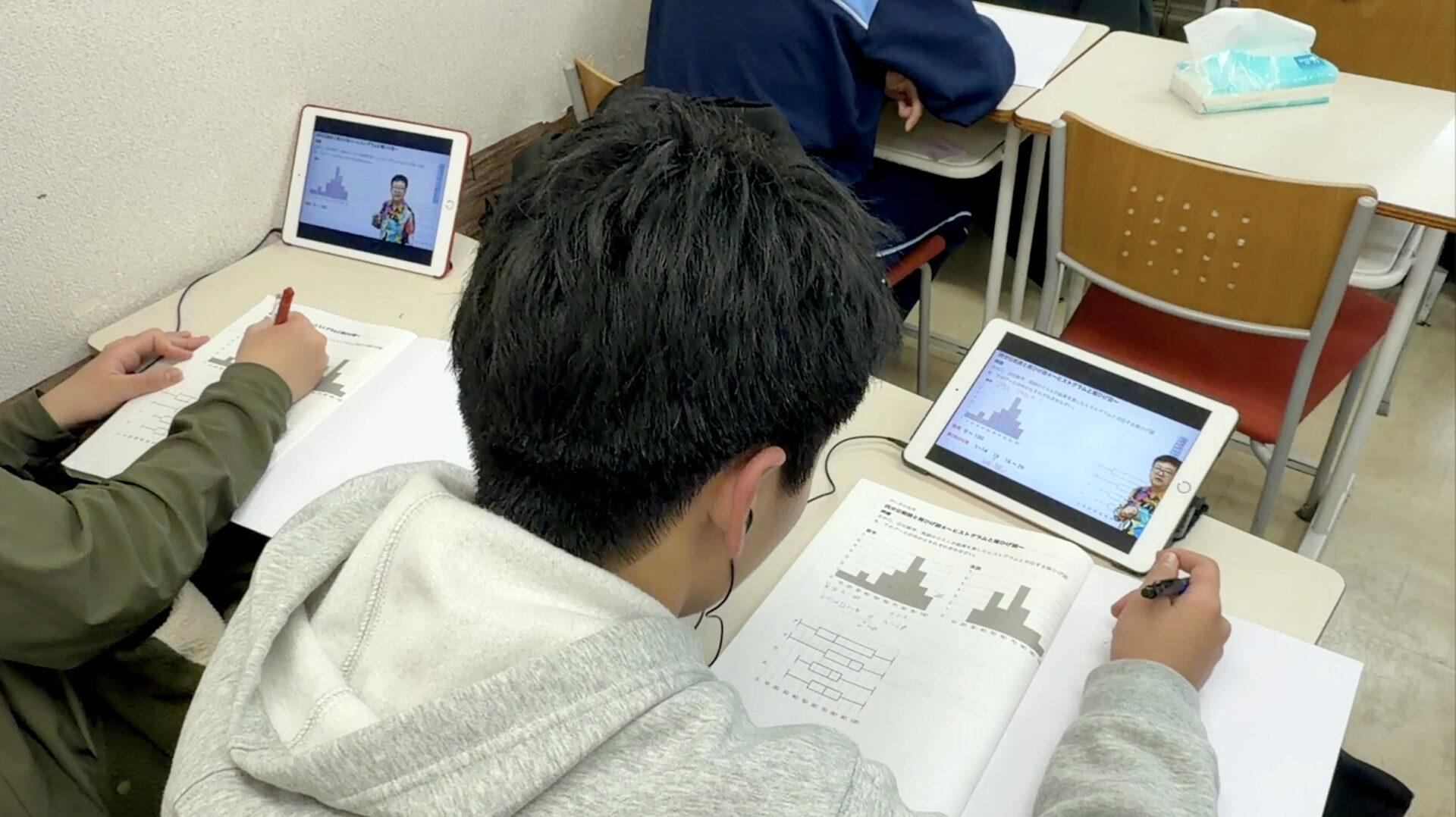 タブレットと教材を組み合わせて学ぶユニバースクールの生徒たち